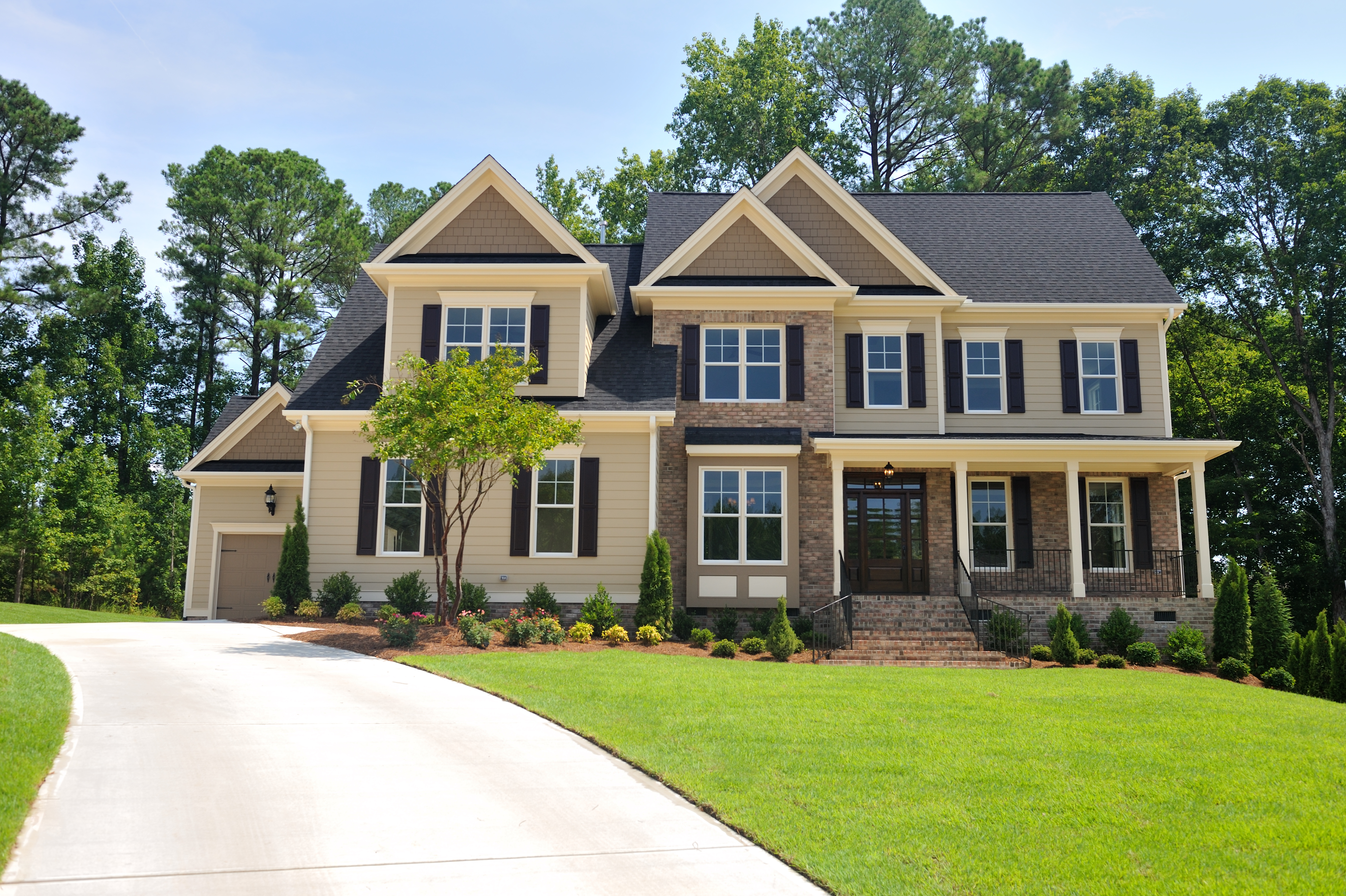 Front view of the extorior of a large home with a well groomed lawn
